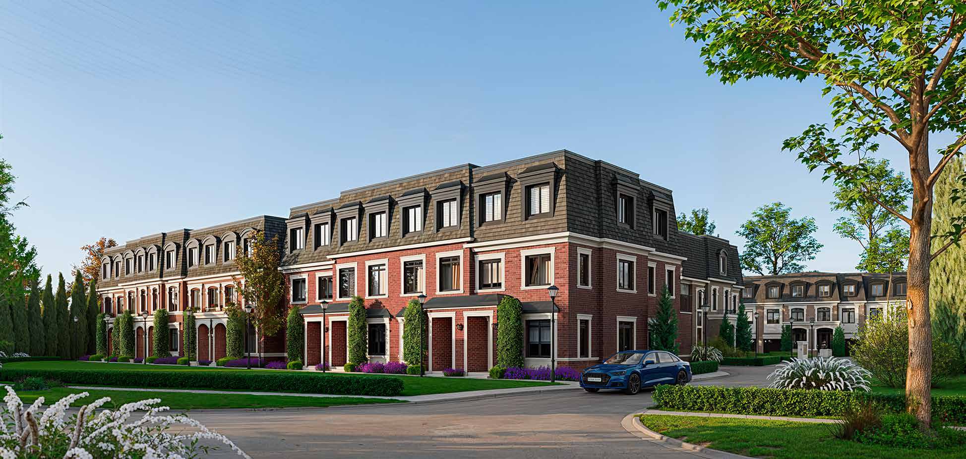 The Victoria Crown site entrance — red-brick Victorian-inspired townhomes with mansard roofs and dormer windows along a tree-lined street